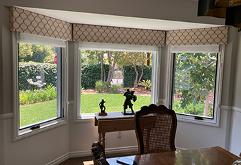 Roller sheer shades paired with Roman printed shades in a stylish living room.